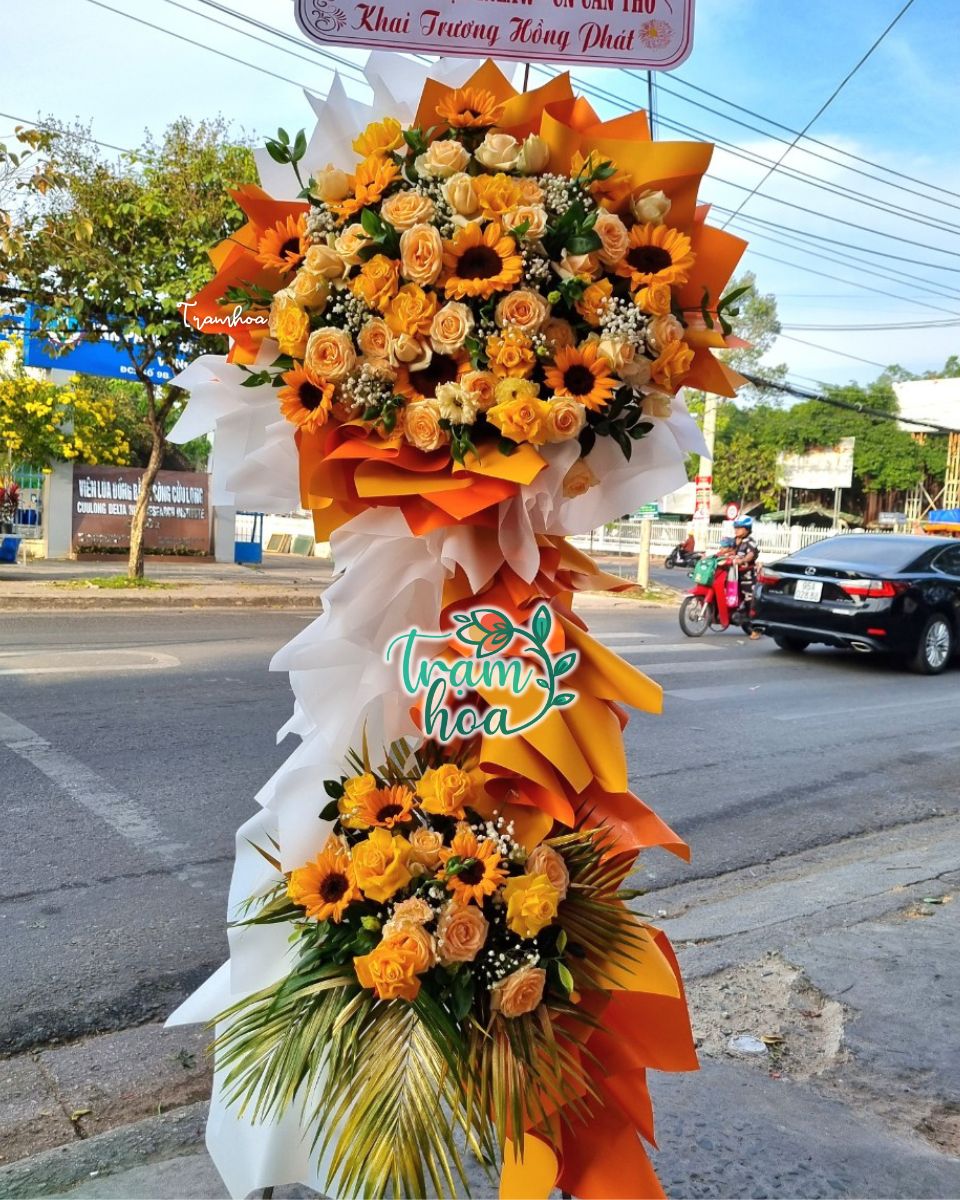 Kệ hoa khai trương tone cam từ hoa hồng cam và hướng dương