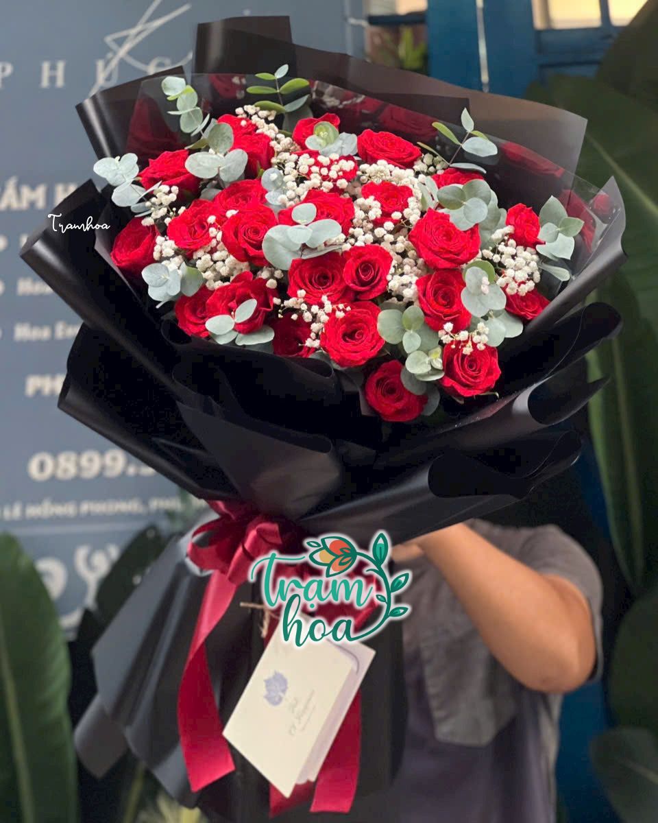 Bó hoa hồng đỏ giấy đen sang trọng đại diện cho tình yêu lãng mạn, phù hợp tặng người phụ nữ tính cách mơ mộng